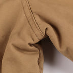 Close-up of brown fabric with visible stitching on a white background