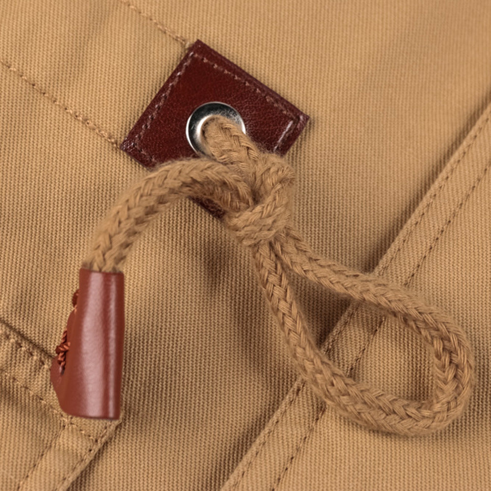 Close-up of a brown leather button and lace on beige fabric